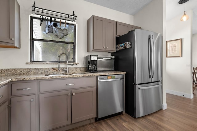 2531 Ludlow St, Deltona, FL 32738 - kitchen with wood finished floors, gray cabinetry, a sink, and appliances with stainless steel finishes