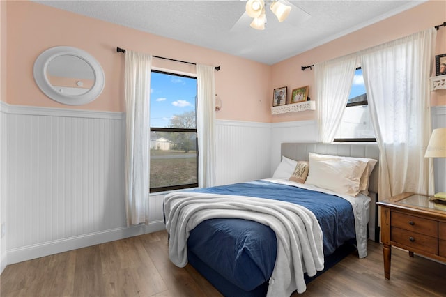2531 Ludlow St, Deltona, FL 32738 - bedroom featuring a textured ceiling, wood finished floors, ceiling fan, and a wainscoted wall