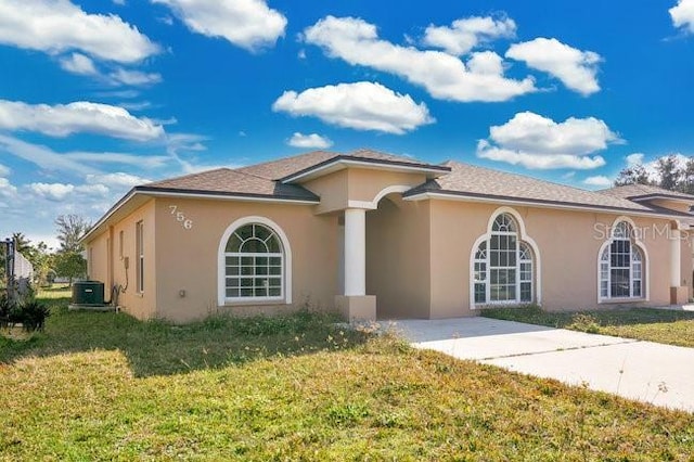 mediterranean / spanish-style home with stucco siding, a front yard, and concrete driveway