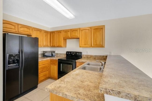 kitchen with a sink, light tile patterned floors, light countertops, black appliances, and a peninsula