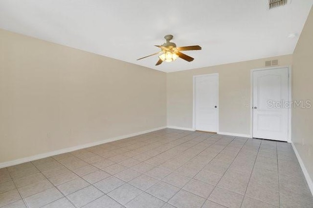 unfurnished bedroom featuring baseboards, visible vents, ceiling fan, and light tile patterned floors