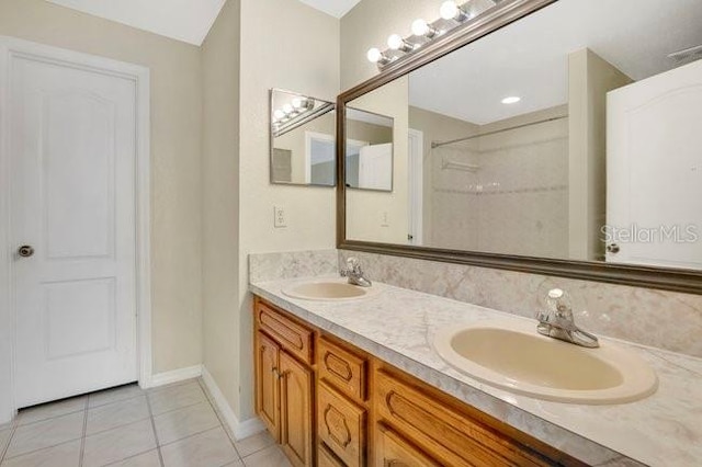 full bath with double vanity, a sink, and tile patterned floors