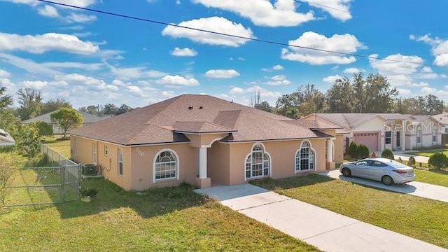 mediterranean / spanish-style home with fence, central AC, stucco siding, and a front yard