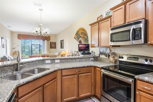 3632 Solana Cir Unit B, Clermont, FL 34711 - kitchen with appliances with stainless steel finishes, a chandelier, open floor plan, and light stone counters