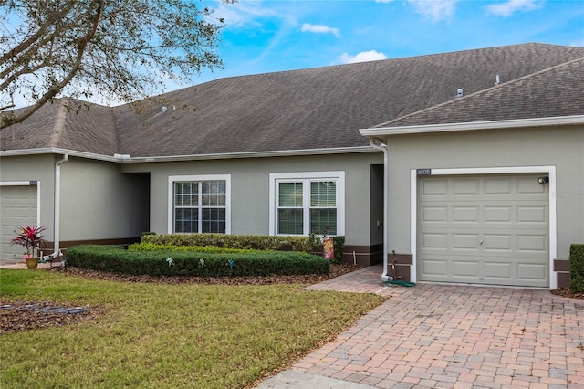 3632 Solana Cir Unit B, Clermont, FL 34711 - view of front of property with a garage, stucco siding, roof with shingles, decorative driveway, and a front yard