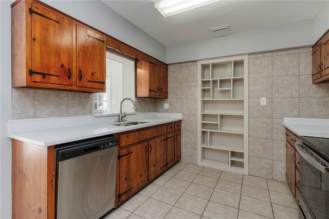 kitchen featuring a sink, appliances with stainless steel finishes, brown cabinetry, and light countertops