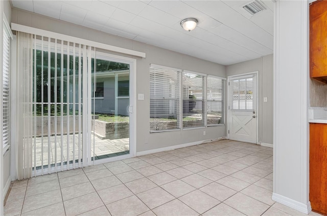 interior space featuring baseboards, visible vents, and light tile patterned floors