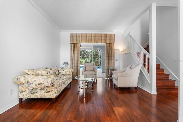 sitting room with stairway, ornamental molding, baseboards, and wood finished floors