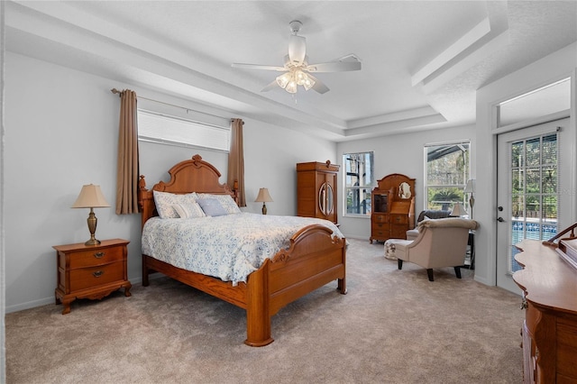 bedroom with ceiling fan, baseboards, light colored carpet, a tray ceiling, and access to outside