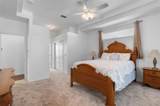 bedroom featuring a closet, visible vents, light colored carpet, and baseboards