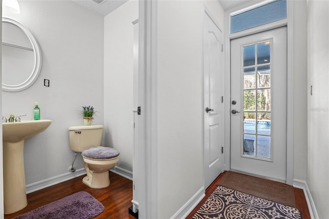 bathroom featuring a sink, baseboards, toilet, and wood finished floors