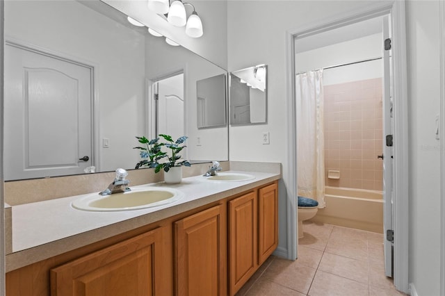 full bathroom with a sink, toilet, double vanity, and tile patterned floors