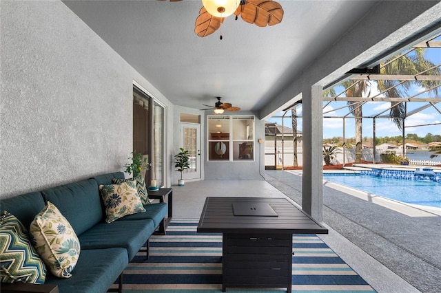 view of patio / terrace with an outdoor pool, ceiling fan, a hot tub, a lanai, and an outdoor hangout area