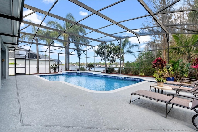 pool with glass enclosure and a patio area