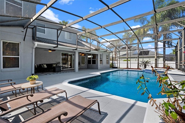 view of pool with glass enclosure, a patio, a ceiling fan, and a pool with connected hot tub