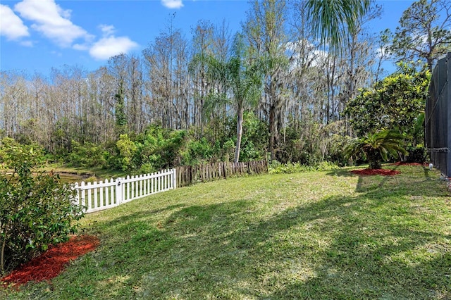 view of yard with fence and a view of trees