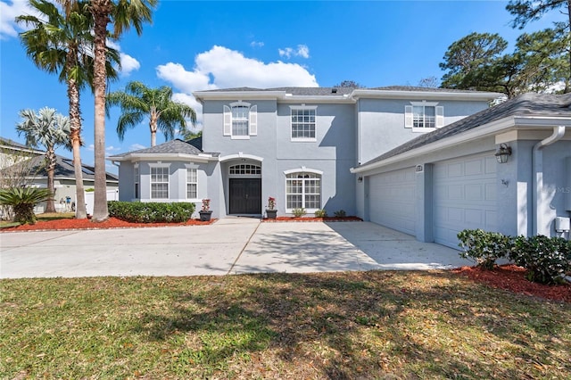 traditional-style home with stucco siding, driveway, and a garage