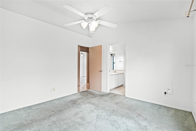 unfurnished bedroom featuring ensuite bathroom, light carpet, and ceiling fan