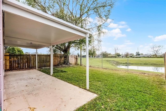 view of yard with a patio, a water view, and a fenced backyard