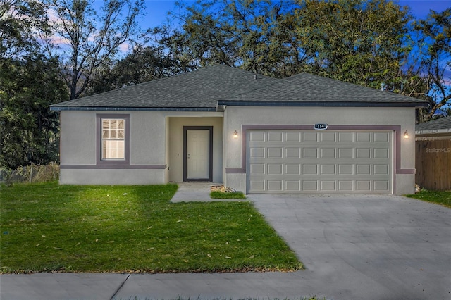 ranch-style home with a front lawn, concrete driveway, an attached garage, and stucco siding