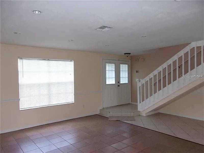 entryway featuring stairway, a healthy amount of sunlight, visible vents, and tile patterned floors