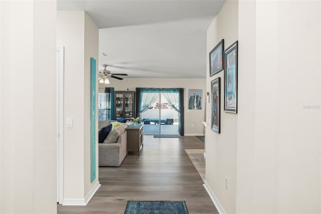 hallway featuring baseboards and wood finished floors