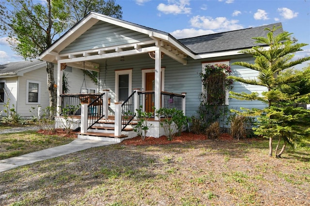 bungalow-style home with covered porch and a shingled roof