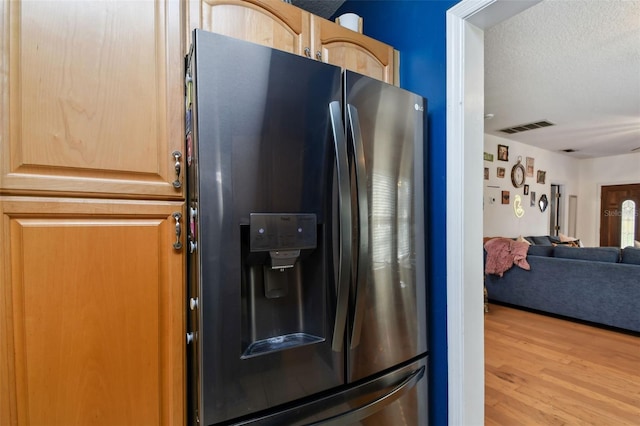 kitchen with visible vents, open floor plan, light wood-type flooring, light brown cabinets, and stainless steel refrigerator with ice dispenser