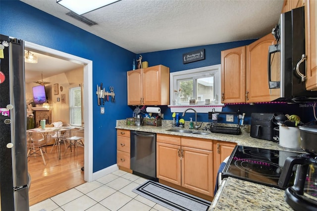 kitchen featuring a textured ceiling, a sink, visible vents, freestanding refrigerator, and dishwasher