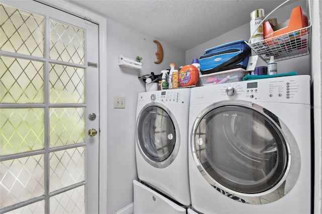 laundry area with laundry area, a textured ceiling, and washer and dryer