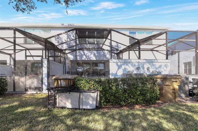17442 Hidden Forest Dr, Clermont, FL 34714 - back of property featuring glass enclosure, a yard, and stucco siding