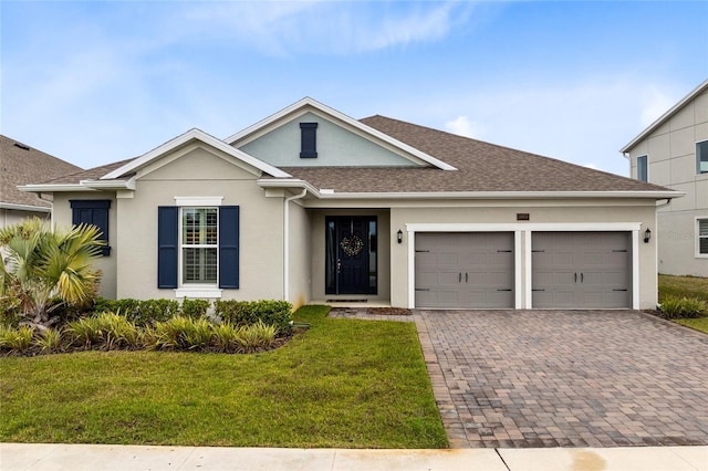 single story home with a garage, roof with shingles, decorative driveway, a front lawn, and stucco siding