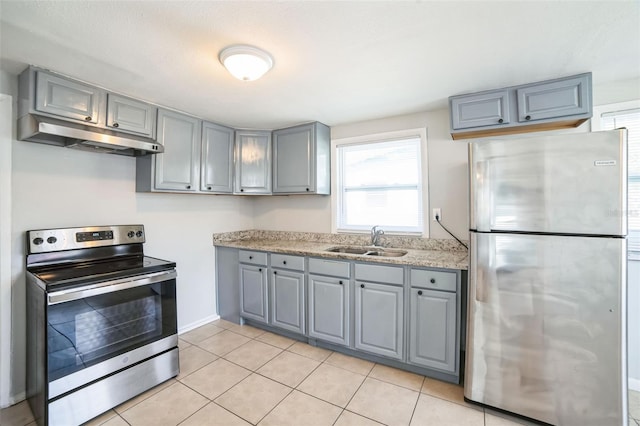 kitchen featuring light tile patterned floors, stainless steel appliances, light countertops, under cabinet range hood, and a sink