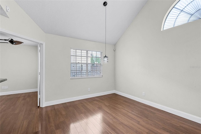 unfurnished room featuring lofted ceiling, dark wood finished floors, and baseboards