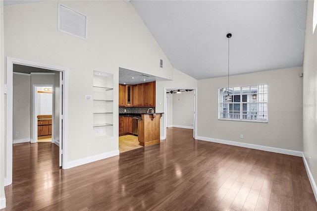 unfurnished living room featuring dark wood-style floors, built in features, visible vents, and baseboards