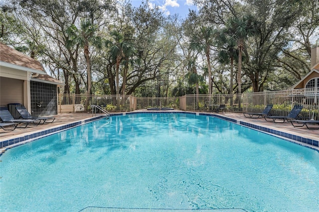 community pool featuring fence and a patio