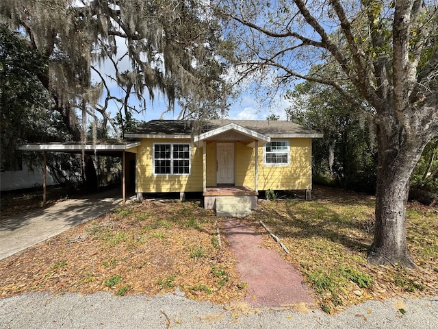 view of front of property featuring an attached carport and driveway