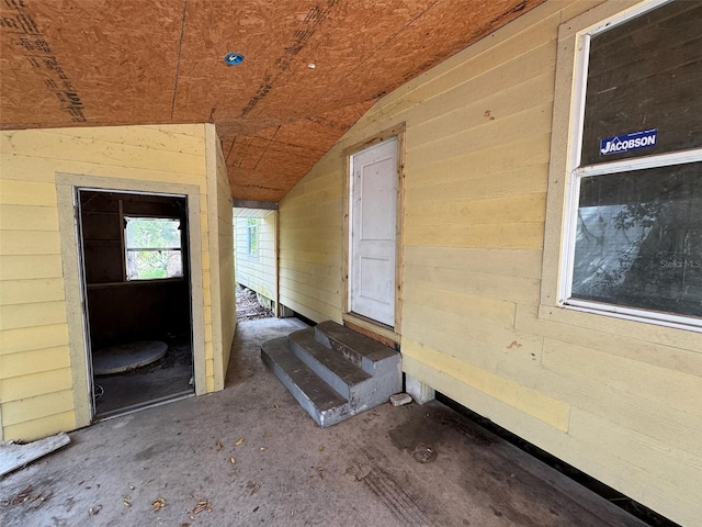 interior space with lofted ceiling and wood walls