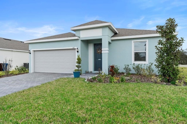 prairie-style home with decorative driveway, an attached garage, a front yard, and stucco siding