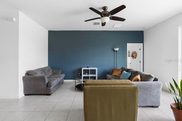 living room with light tile patterned floors, baseboards, visible vents, and a ceiling fan