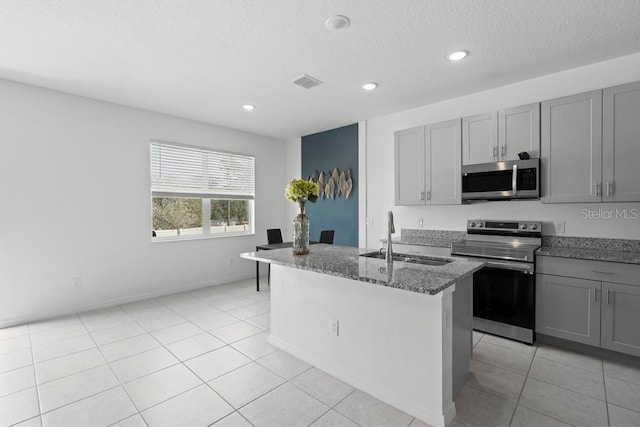 kitchen featuring appliances with stainless steel finishes, gray cabinets, visible vents, and a sink