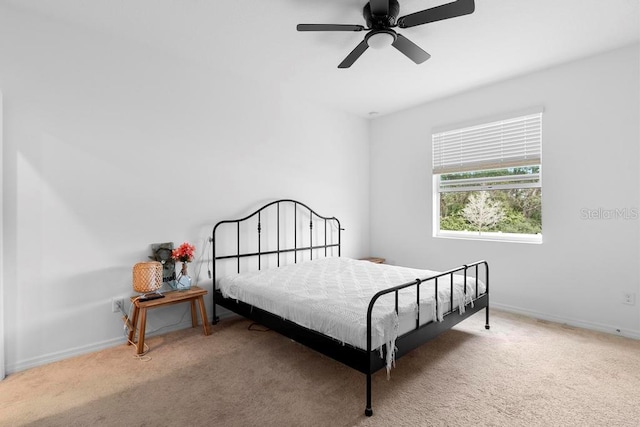 carpeted bedroom featuring a ceiling fan and baseboards