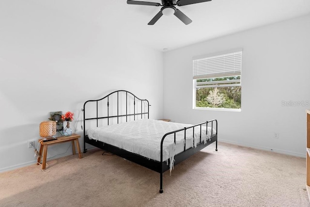 carpeted bedroom featuring baseboards and a ceiling fan