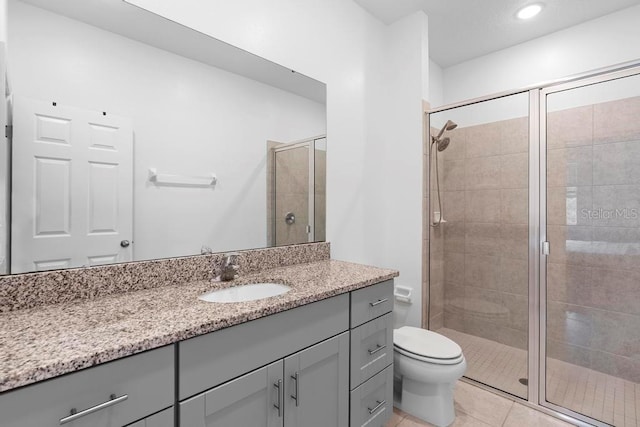 bathroom featuring toilet, recessed lighting, vanity, a shower stall, and tile patterned floors