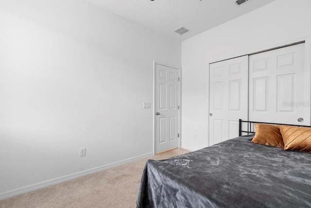 bedroom with a closet, carpet, visible vents, and baseboards