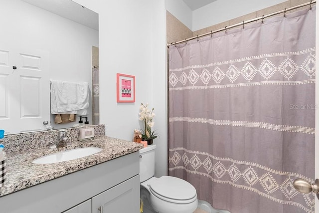 full bathroom featuring toilet, curtained shower, and vanity