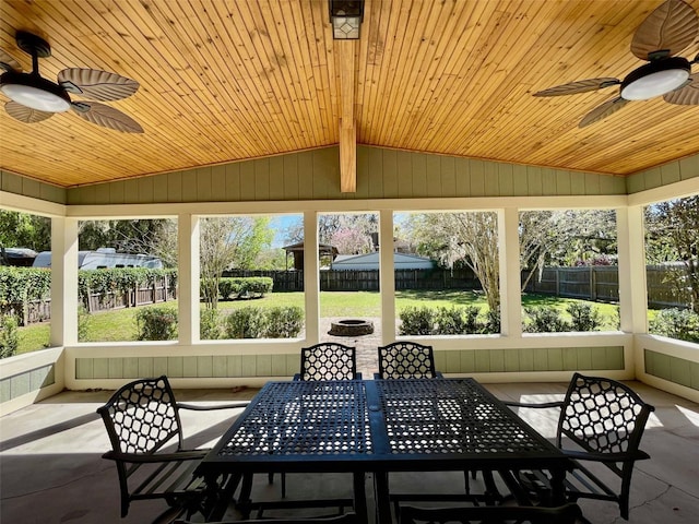 sunroom with lofted ceiling, wood ceiling, and ceiling fan