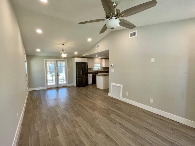 unfurnished living room featuring french doors, dark wood-type flooring, visible vents, and baseboards