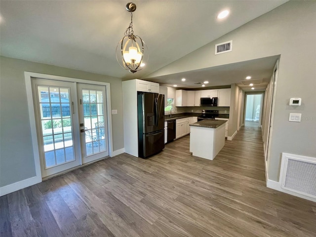 kitchen featuring lofted ceiling, black appliances, dark countertops, and visible vents