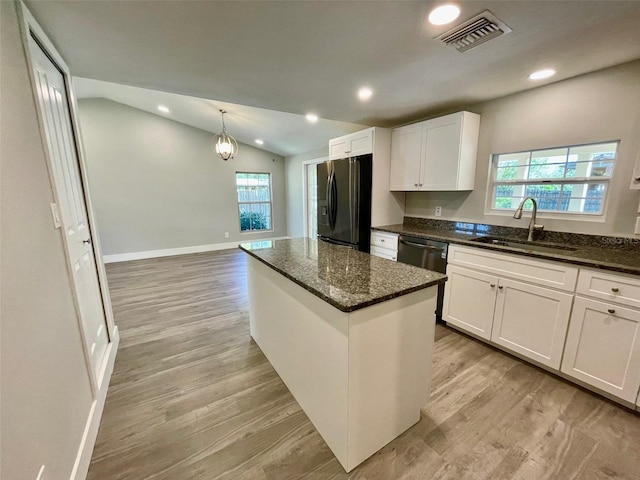 kitchen with lofted ceiling, visible vents, black fridge with ice dispenser, a sink, and plenty of natural light